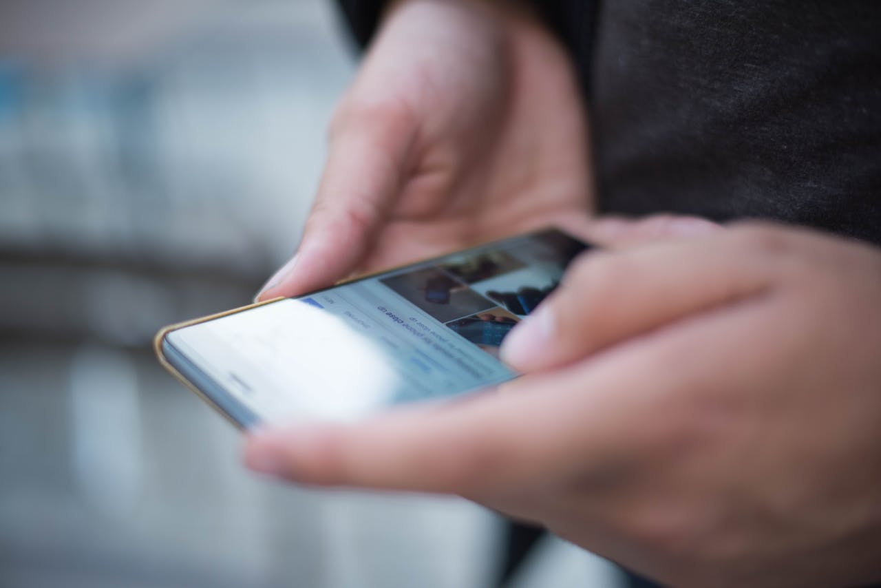 about-us Close-up of hands using a smartphone with a touchscreen, emphasizing mobile technology.